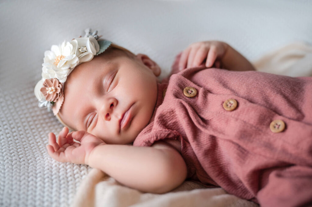 Are Newborn Photos Worth It? Newborn baby in pink outfit. 